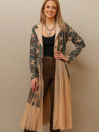 Woman wearing a flowing women’s western kimono styled with denim jeans and cowboy boots for a boho cowgirl fashion look.