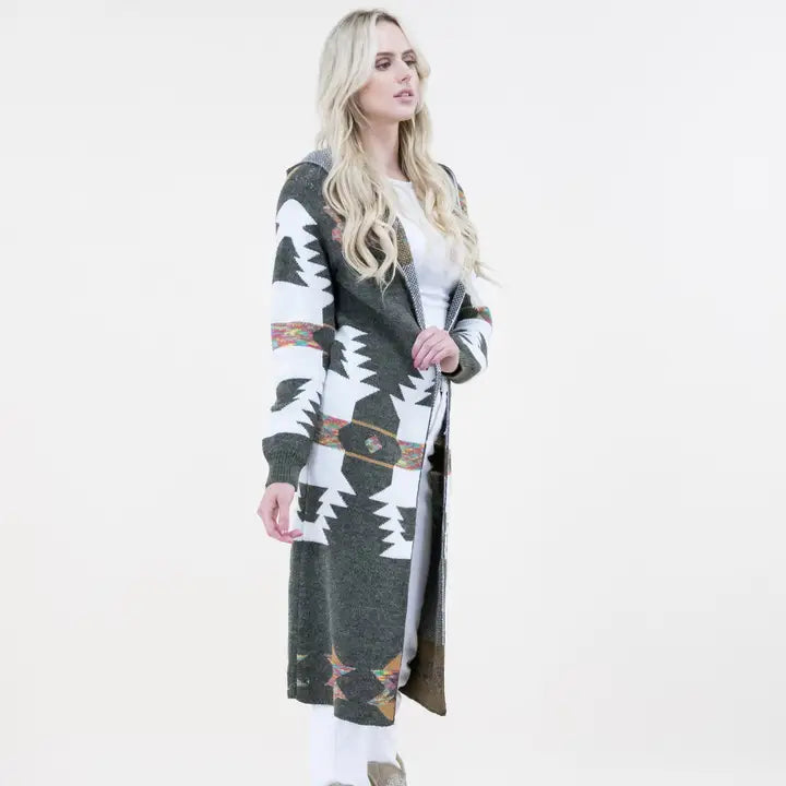 Curvy woman wearing a long Aztec print hoodie cardigan styled for plus size western wear fashion with boots and jeans.