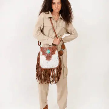 Fashionable western handbag styled with denim, boots, and country-inspired clothing for a modern rodeo outfit.