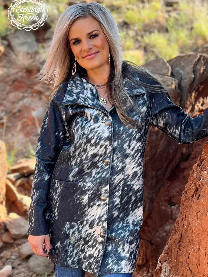 Woman wearing an Aztec patterned women’s western cardigan styled with denim jeans and cowboy boots for a cozy cowgirl look.
