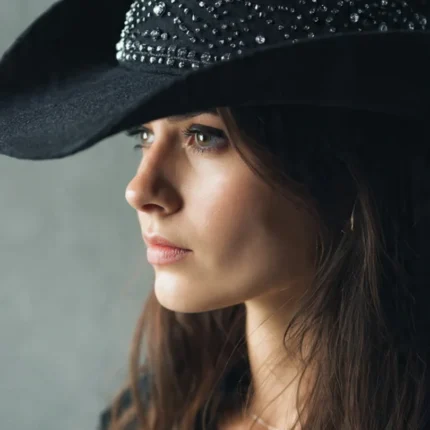 Women wearing a black diamante cowboy hat with sparkling crystal details and wide brim