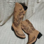 White butterfly cowgirl boots featuring vibrant stitched butterflies and pointed toe design.