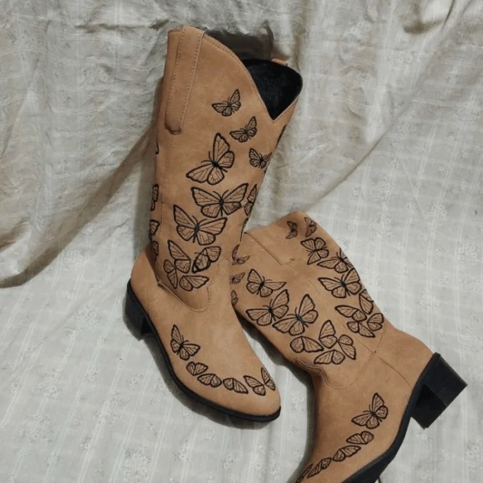 White butterfly cowgirl boots featuring vibrant stitched butterflies and pointed toe design.