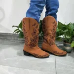 Tan boots with butterflies stitched in colorful patterns on mid-calf Western leather boots.