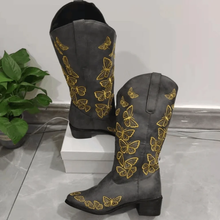 Butterfly boots in brown leather with colorful embroidered butterfly patterns and stacked Western heel.