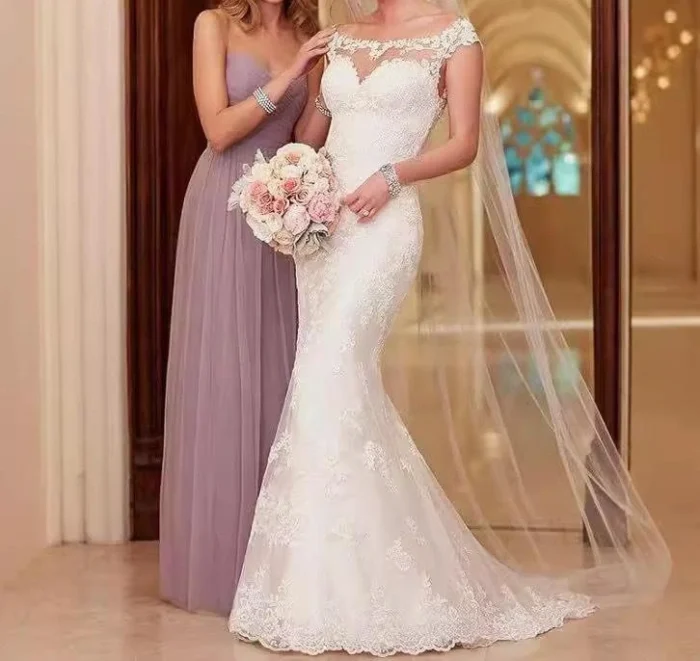 Bride wearing whimsical wedding dress with lace sleeves and flowing tulle skirt in a garden setting