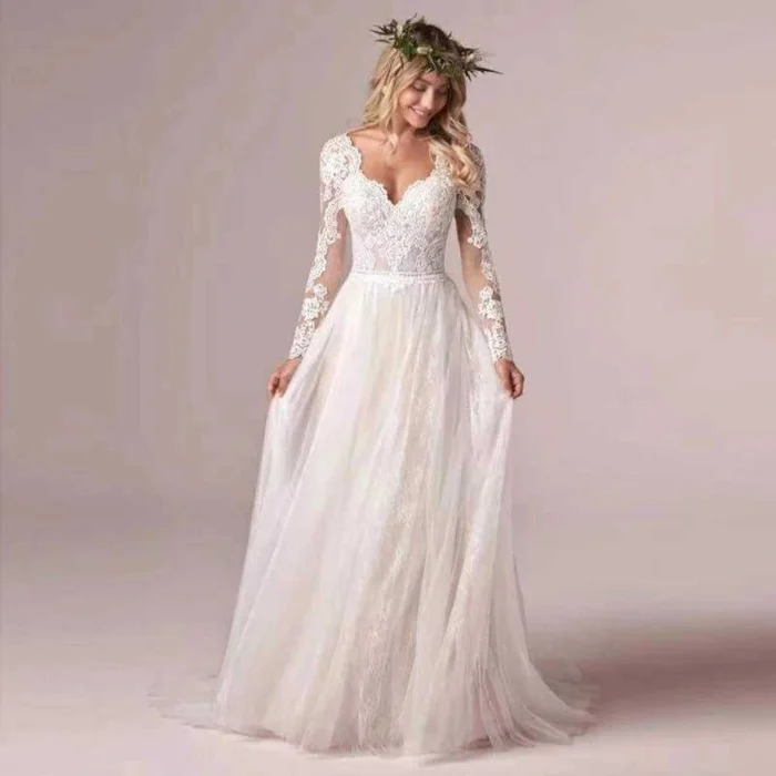 Elegant tulle ball gown wedding dress with long sheer sleeves and voluminous skirt