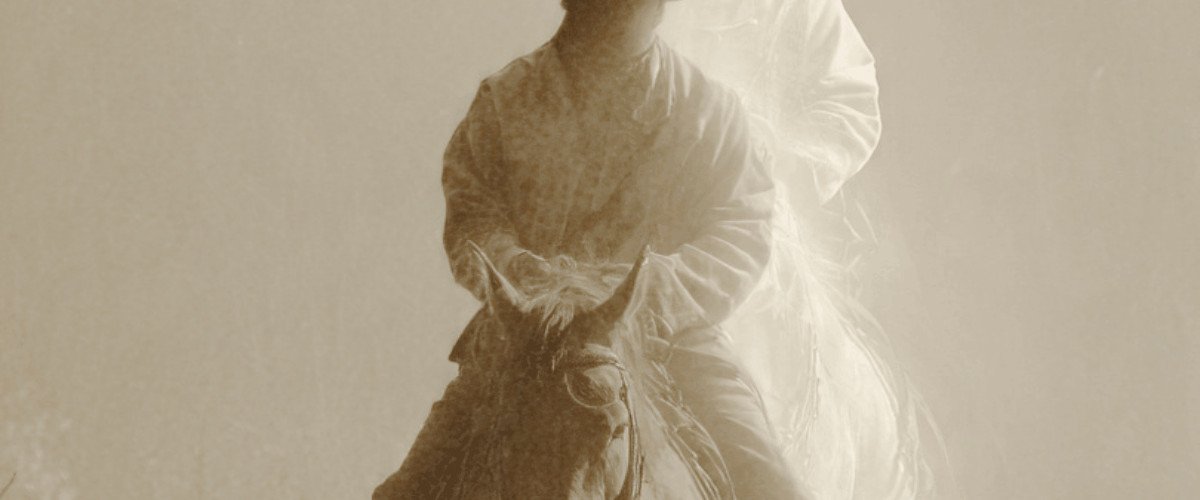 ghost cowboy riding horse at night on desert trail with western hat and long coat