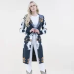Woman wearing an Aztec print hoodie long cardigan styled with denim jeans and cowboy boots for a cozy western fashion look.