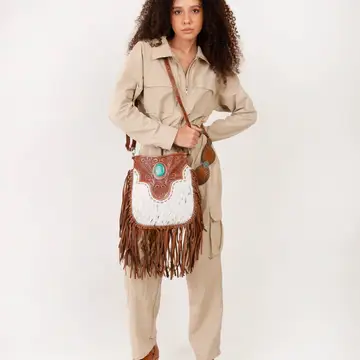 Fashionable western handbag styled with denim, boots, and country-inspired clothing for a modern rodeo outfit.