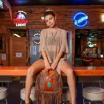 Rustic Ranch Style Handbag featuring western-inspired details paired with cowboy boots and denim for a classic cowgirl look.